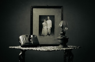 A vintage photo frame resting gently on a light grey wooden table, symbolizing treasured memories.