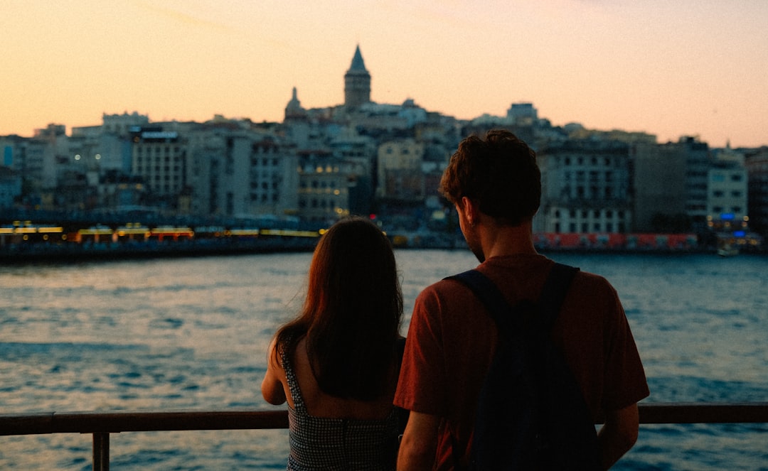 a man and woman looking at the water,