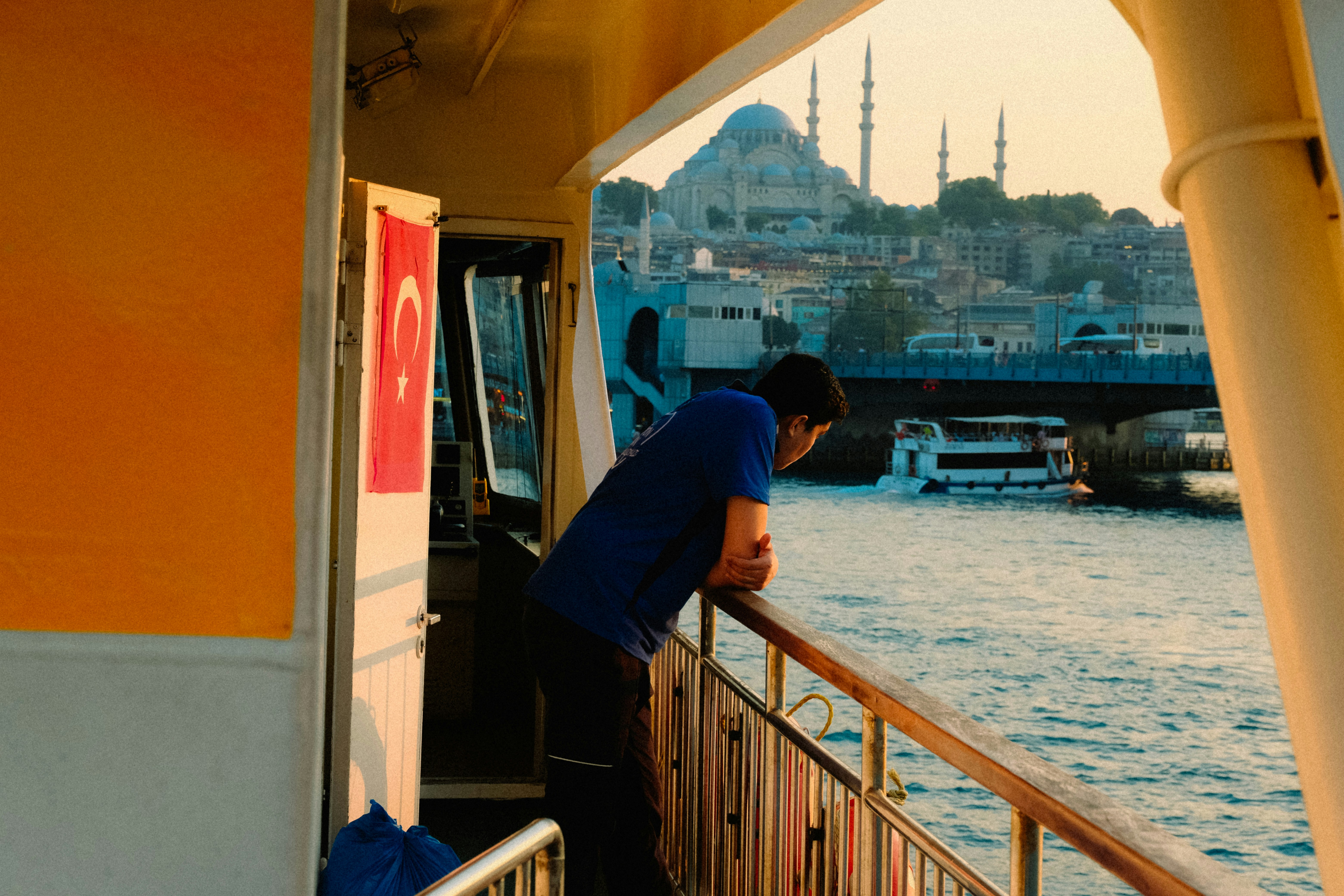 a man leaning on a railing looking out at the water