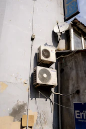 a group of white and black satellite dishes on a white building