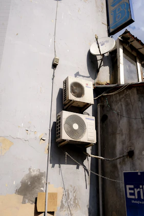 a group of white and black satellite dishes on a white building