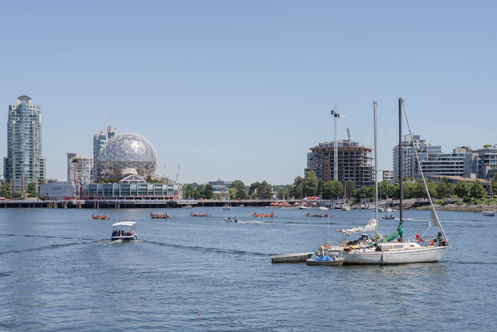 a group of boats in a body of water with buildings in the background