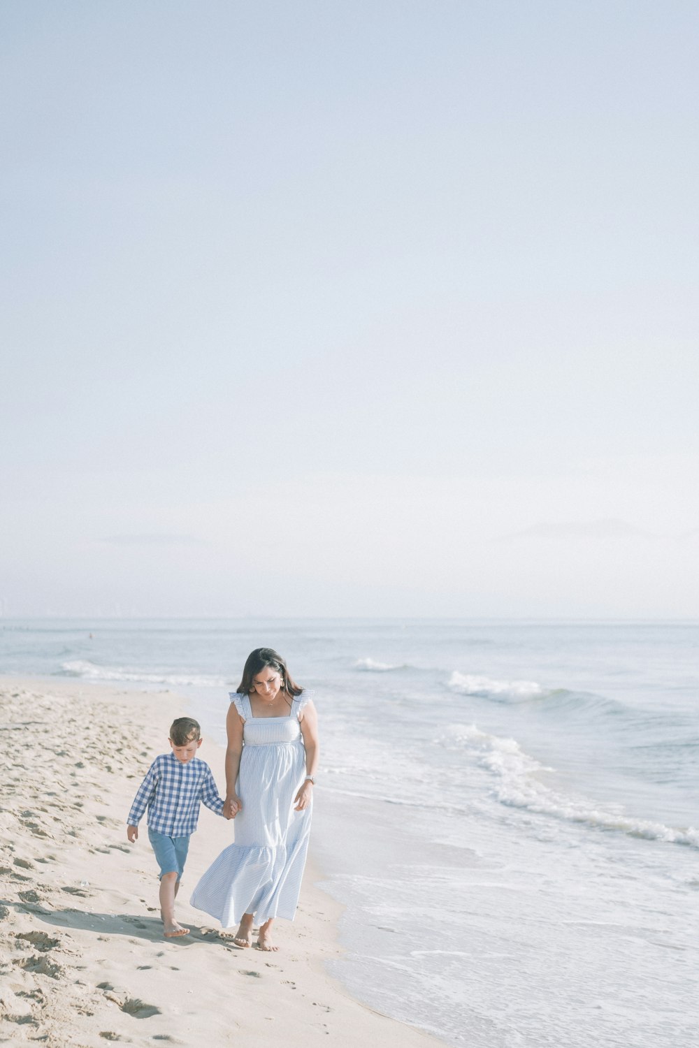 a person and a boy walking on a beach