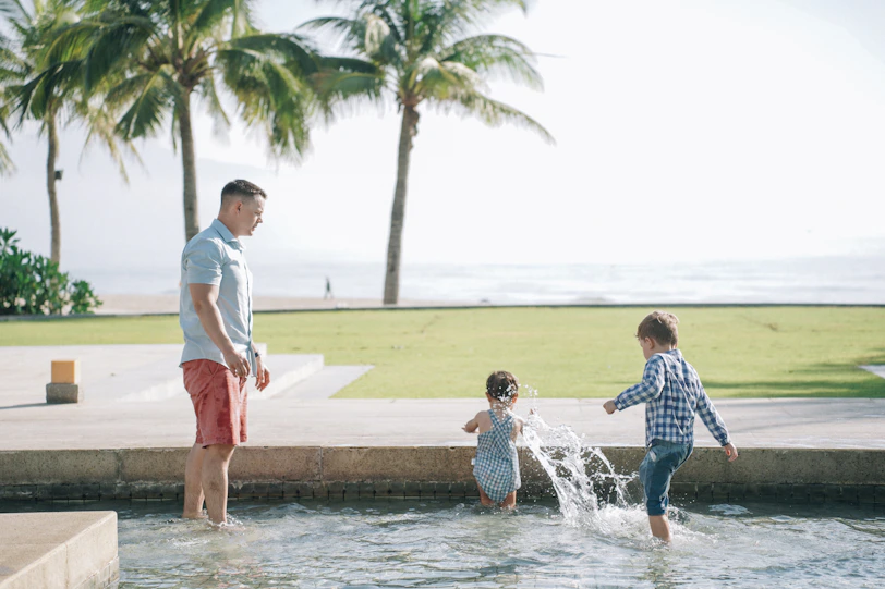 Family splashing in pool at all-inclusive resort with palm trees