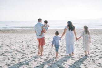a group of people standing on top of a sandy beach