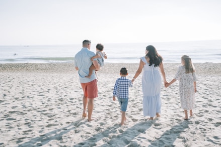 a group of people standing on top of a sandy beach