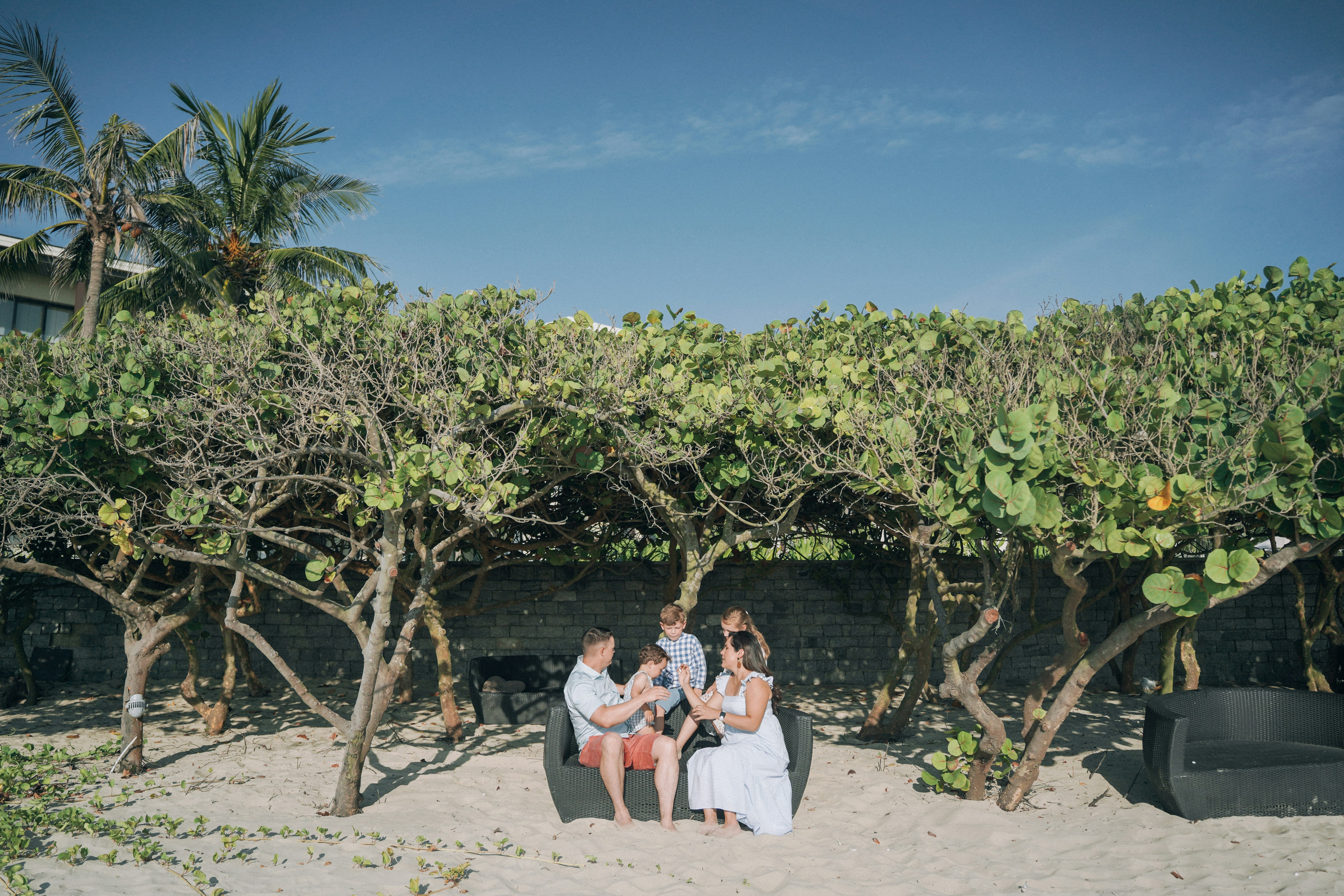 a group of people sitting on a bench in front of a tree