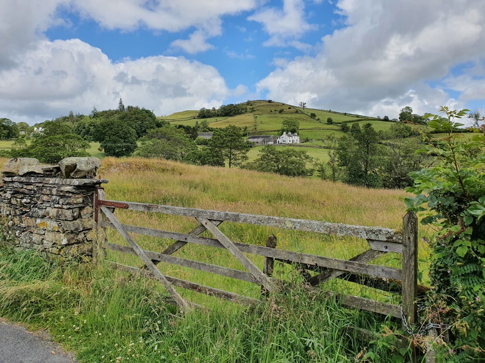 a wooden fence in a grassy field