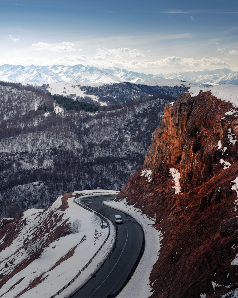 a road going through a snowy mountainous region