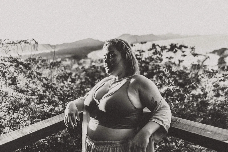 Thoughtful BBW woman sitting on a ledge