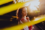 Mujer usando collar de macramé al aire libre con vegetación y luz natural.