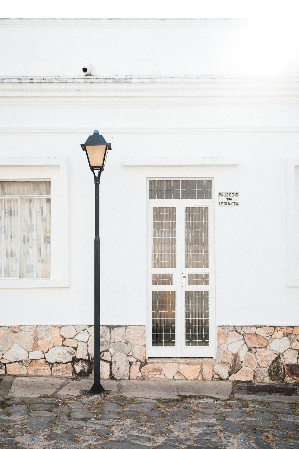 a lamp post next to a white building