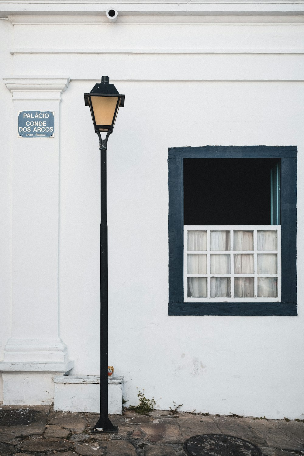 a lamp post in front of a white building