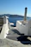 Gentle waves lapping white stone steps leading to a sunlit Greek villa, embodying tranquility.