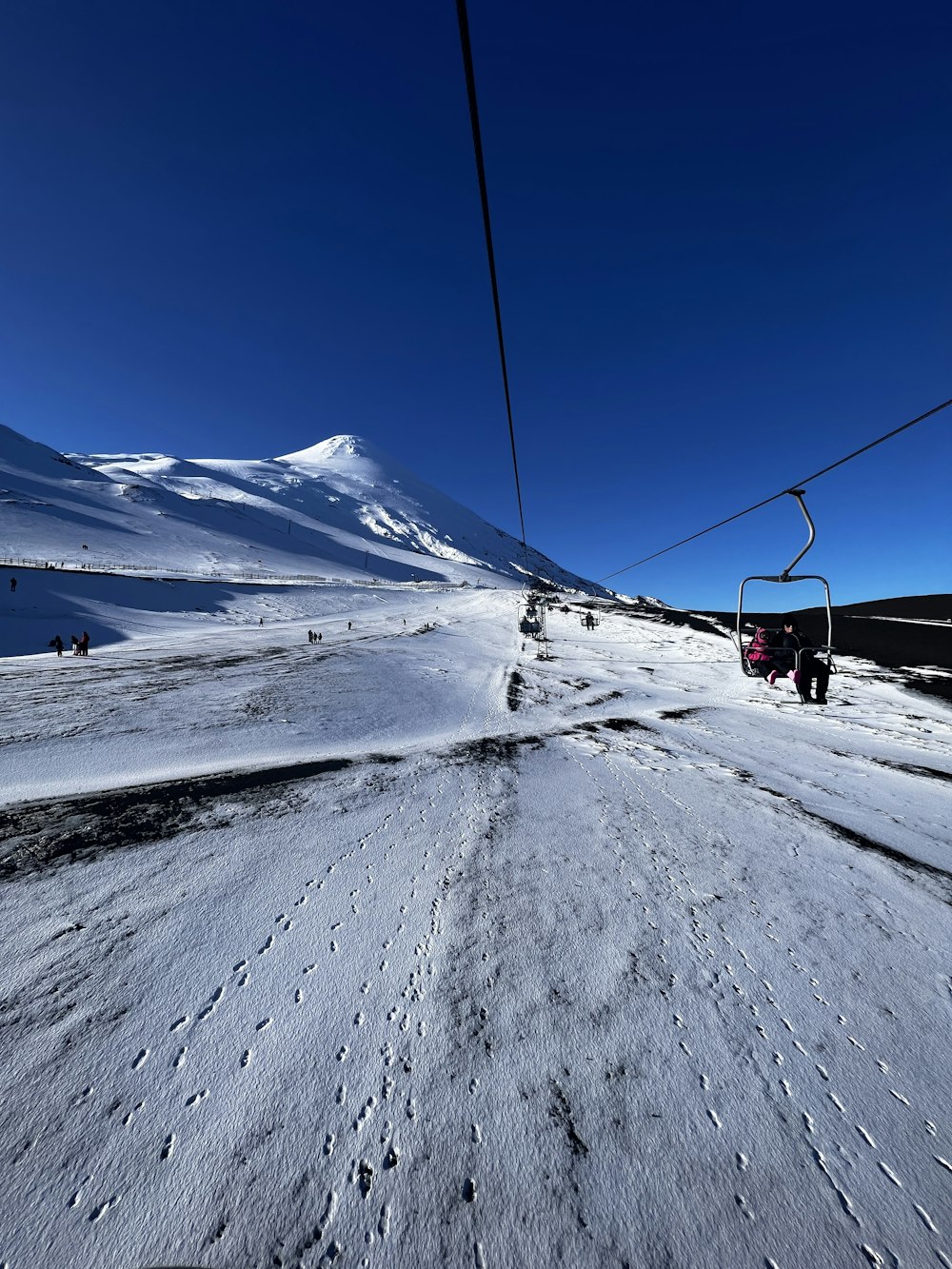 a ski lift going up a snowy mountain