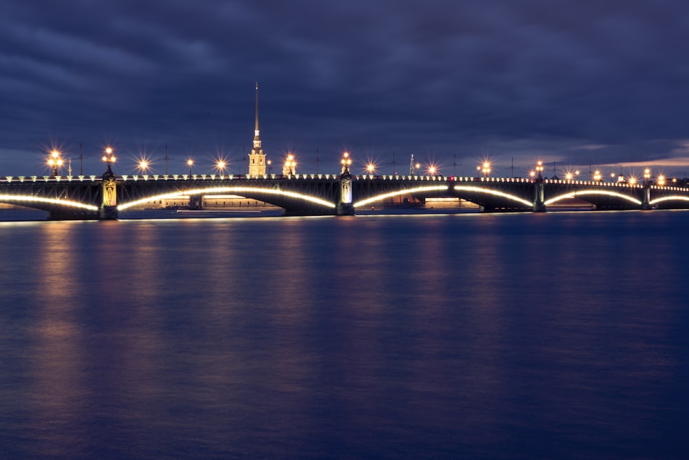 a bridge over water with a tower in the background