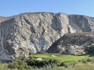 Players teeing off with a backdrop of rugged outback terrain.