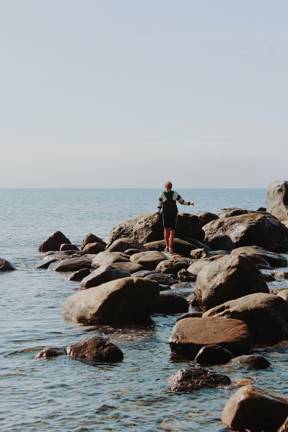 a person standing on a rock in the water