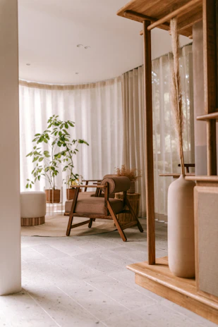 A serene living room showcasing warm wood tones, soft natural light, and simple Japandi furniture.