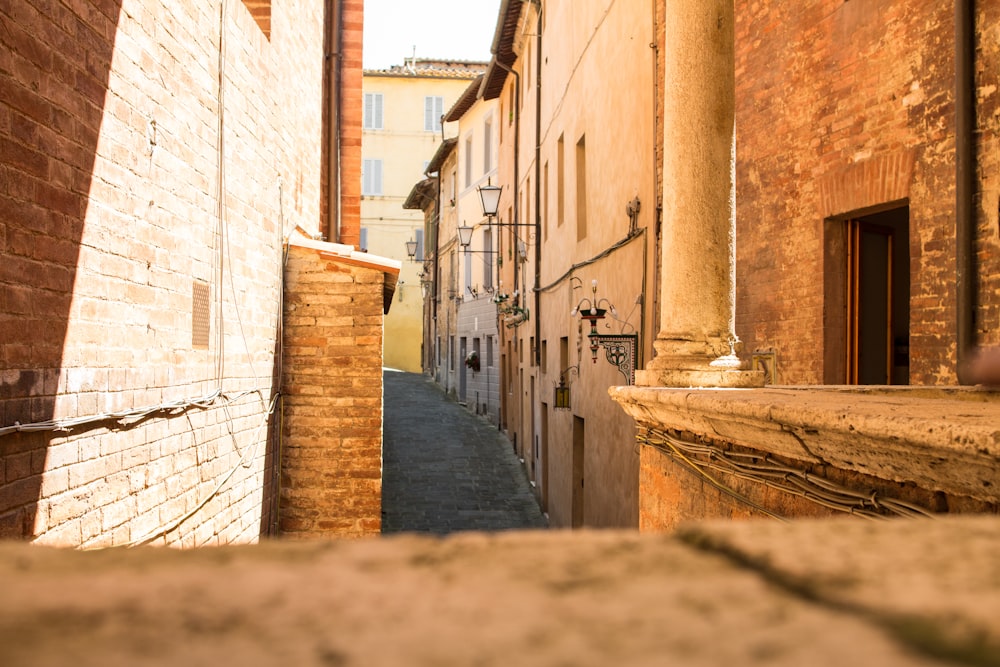 a narrow alley between two brick buildings