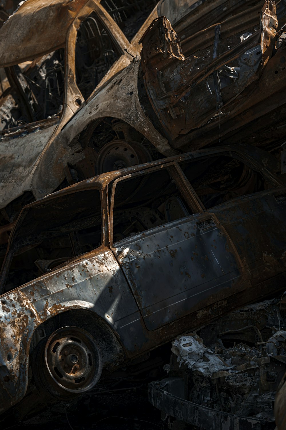 a rusted car with a broken front wheel