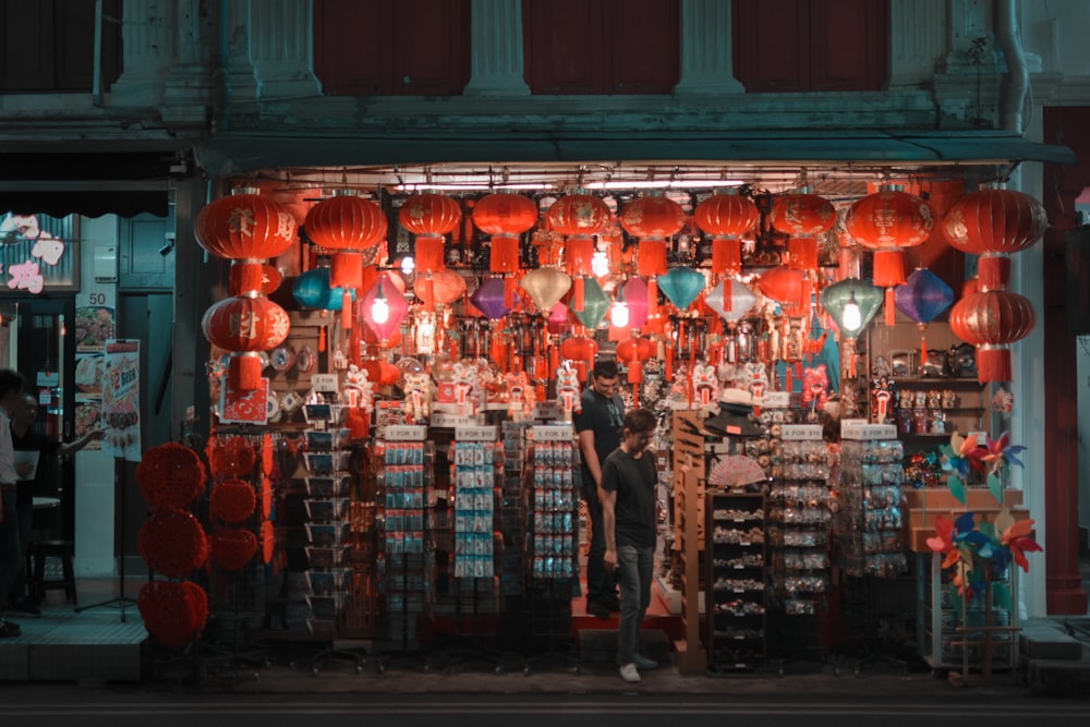 a group of people standing in front of a store with lanterns