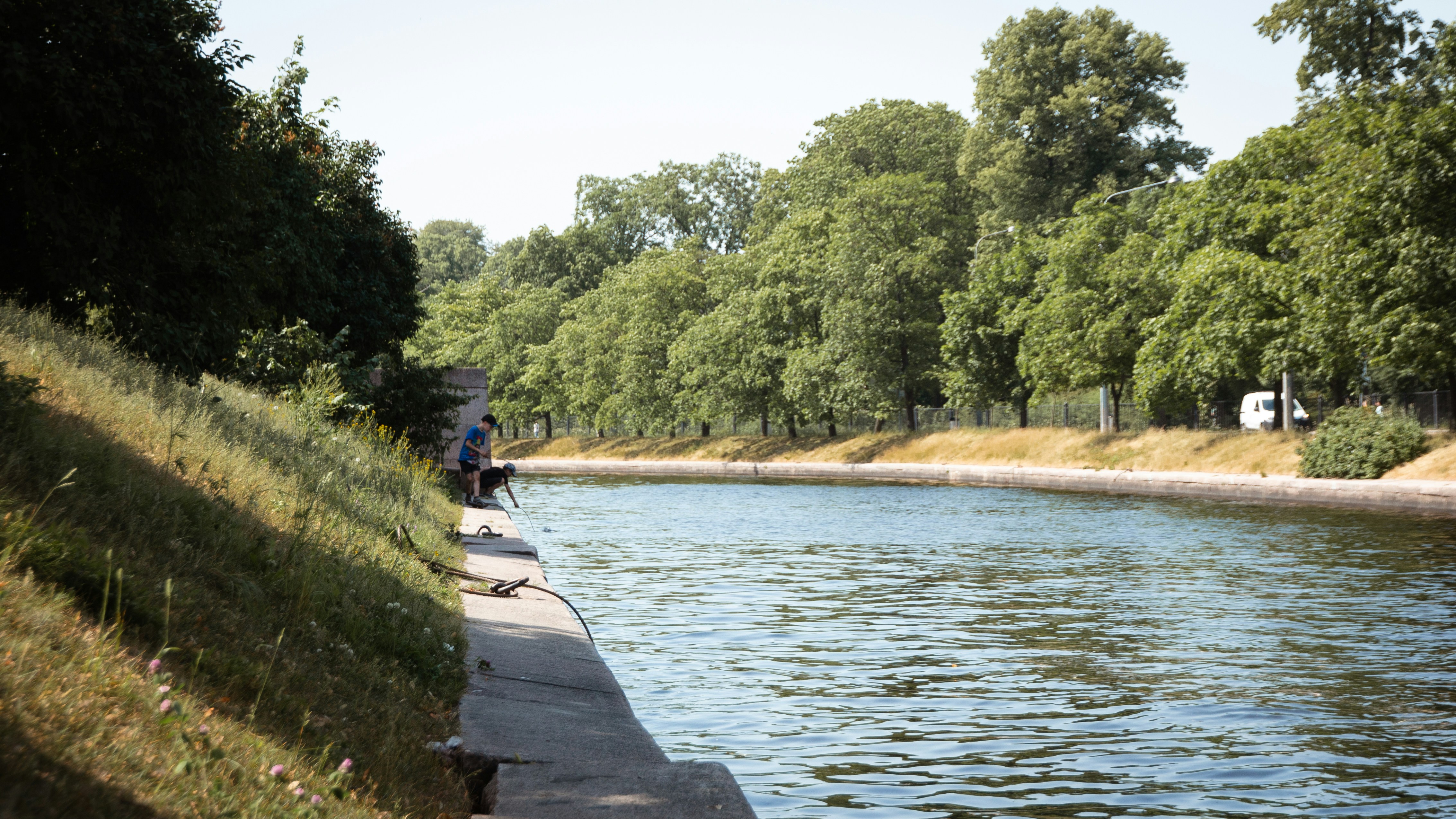 a person sitting on a bench by a river