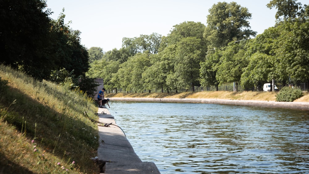 a person sitting on a bench by a river