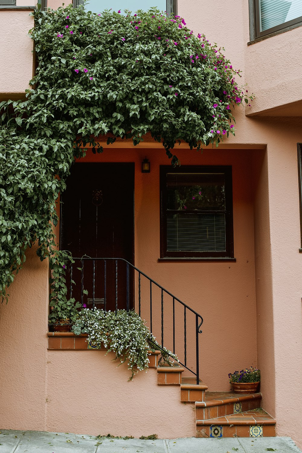 a house with a balcony and plants on the side