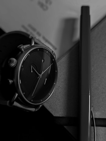 Minimalist black and white photo of a wrist wearing a GMT watch, highlighting its sharp details.