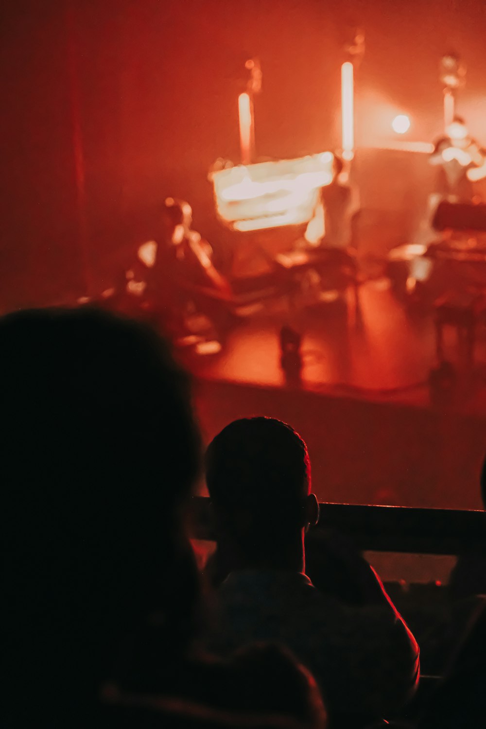 a person sitting in front of a stage with candles