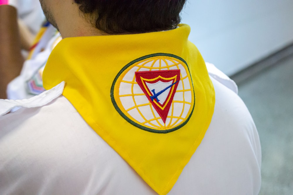 a man wearing a yellow shirt with a blue and yellow logo