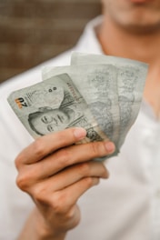 a person holding a stack of paper money