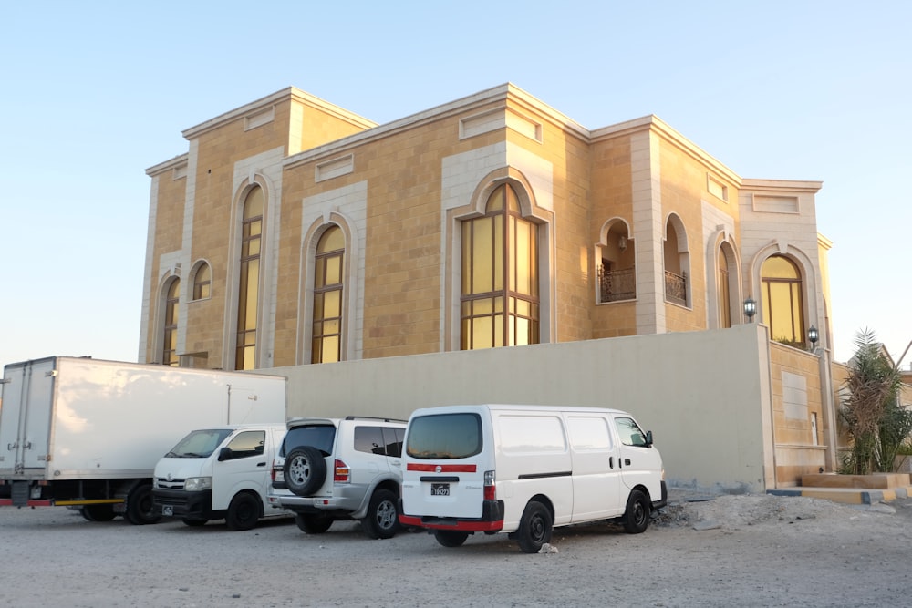 a group of white trucks parked outside a building