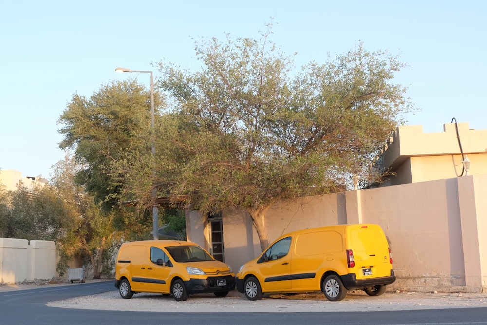 two yellow cars parked in front of a building