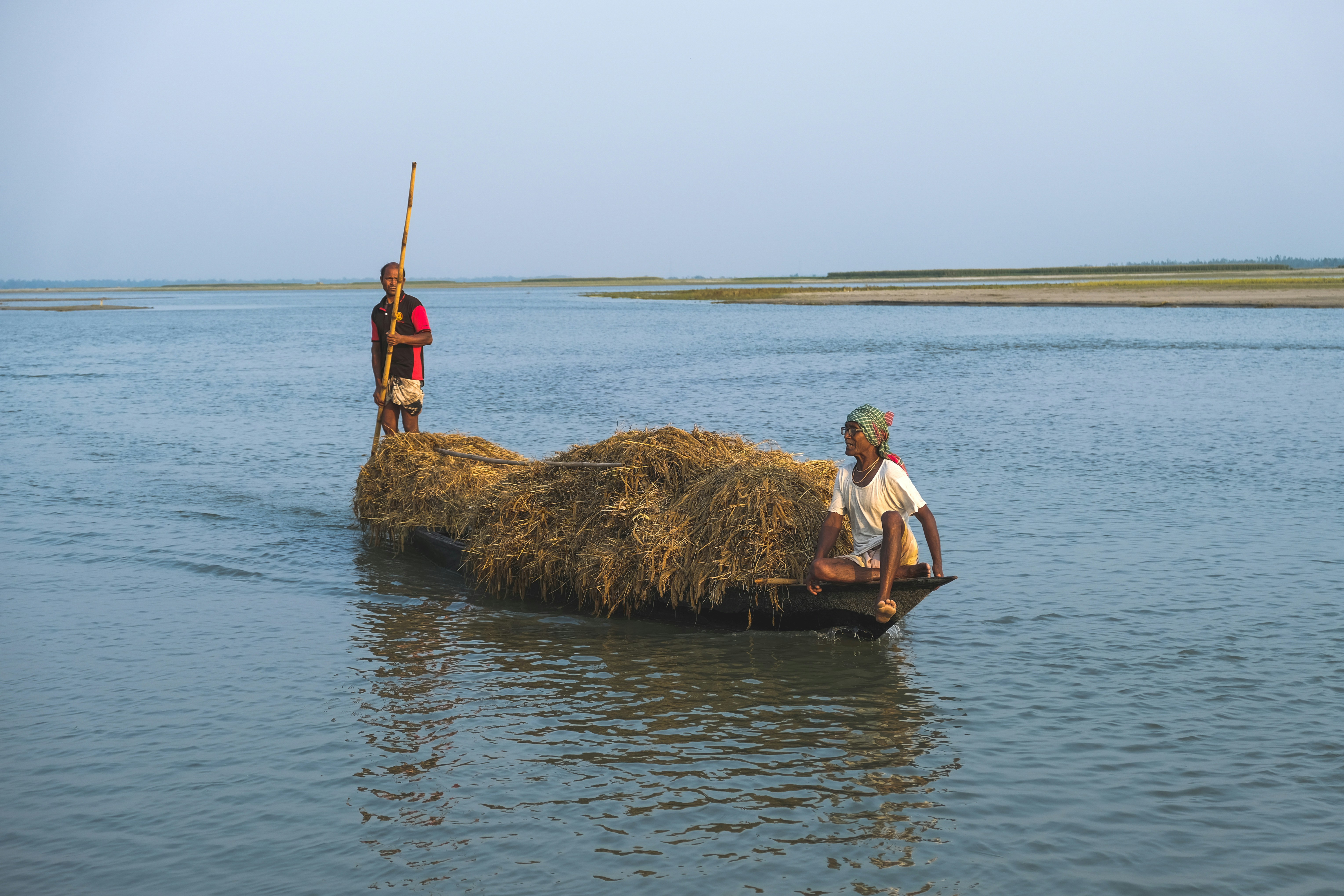 a man and a woman on a boat with a large rock in the water