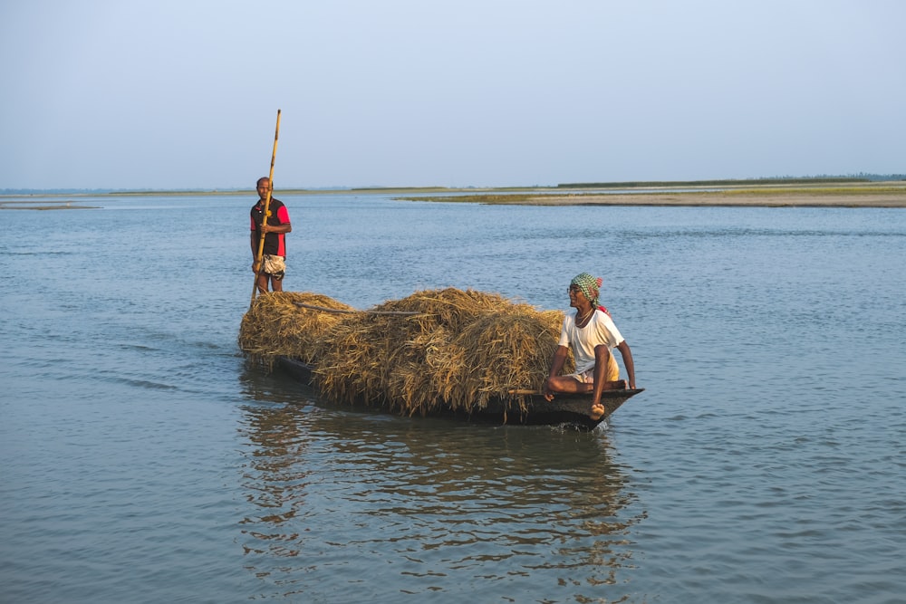 a man and a woman on a boat with a large rock in the water