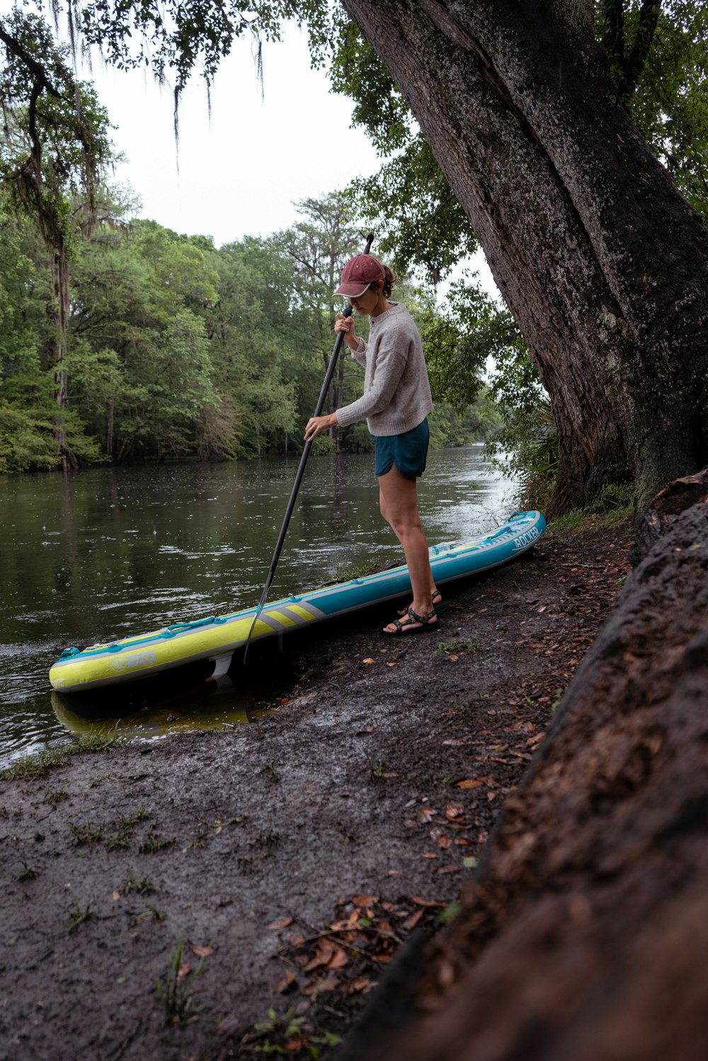 a person standing on a log next to a kayak