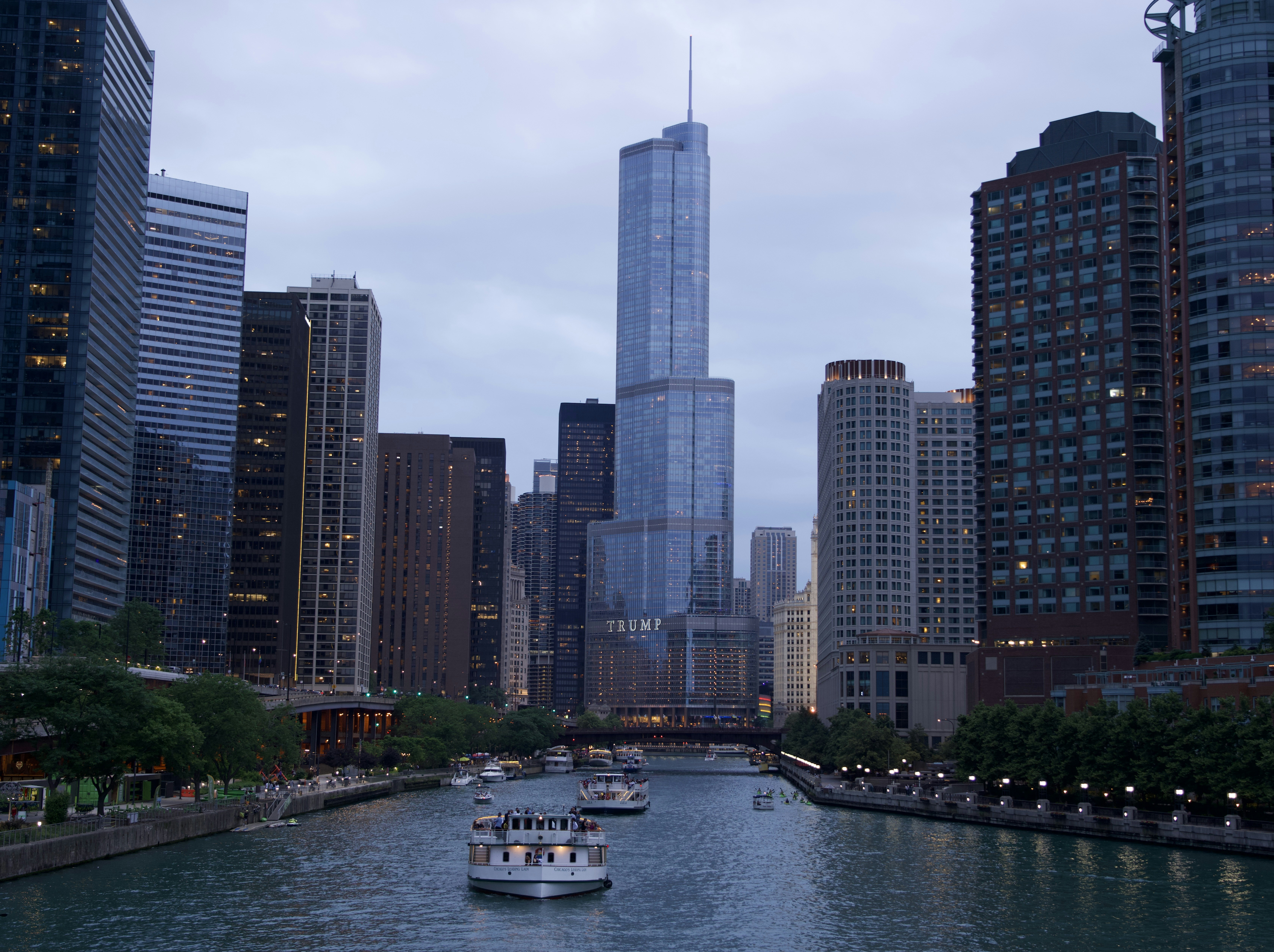 a river with boats in it and tall buildings in the back