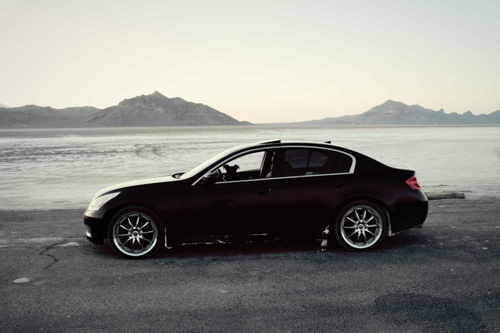 a car parked on a road by water