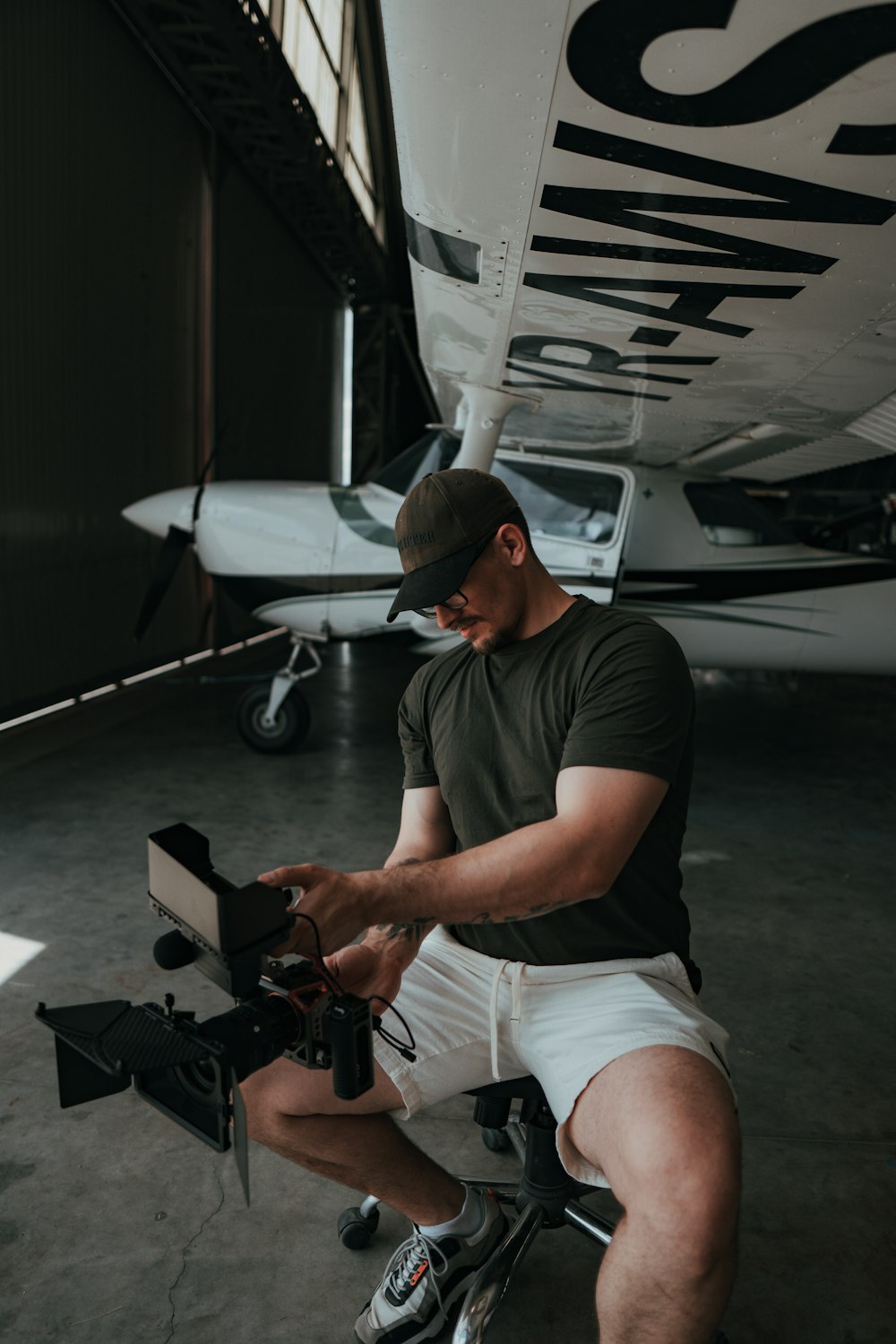 a man sitting on a chair with a laptop and a drone