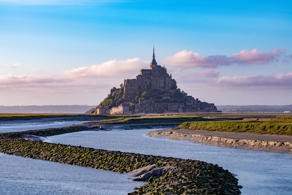 a castle on a hill with Mont Saint-Michel in the background