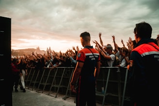 a group of people standing on a bridge with a crowd watching
