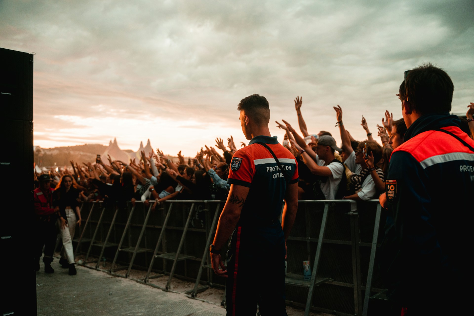 a group of people standing on a bridge with a crowd watching