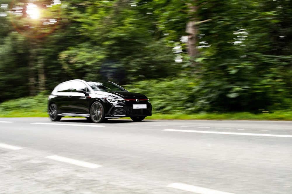 a black car driving on a road