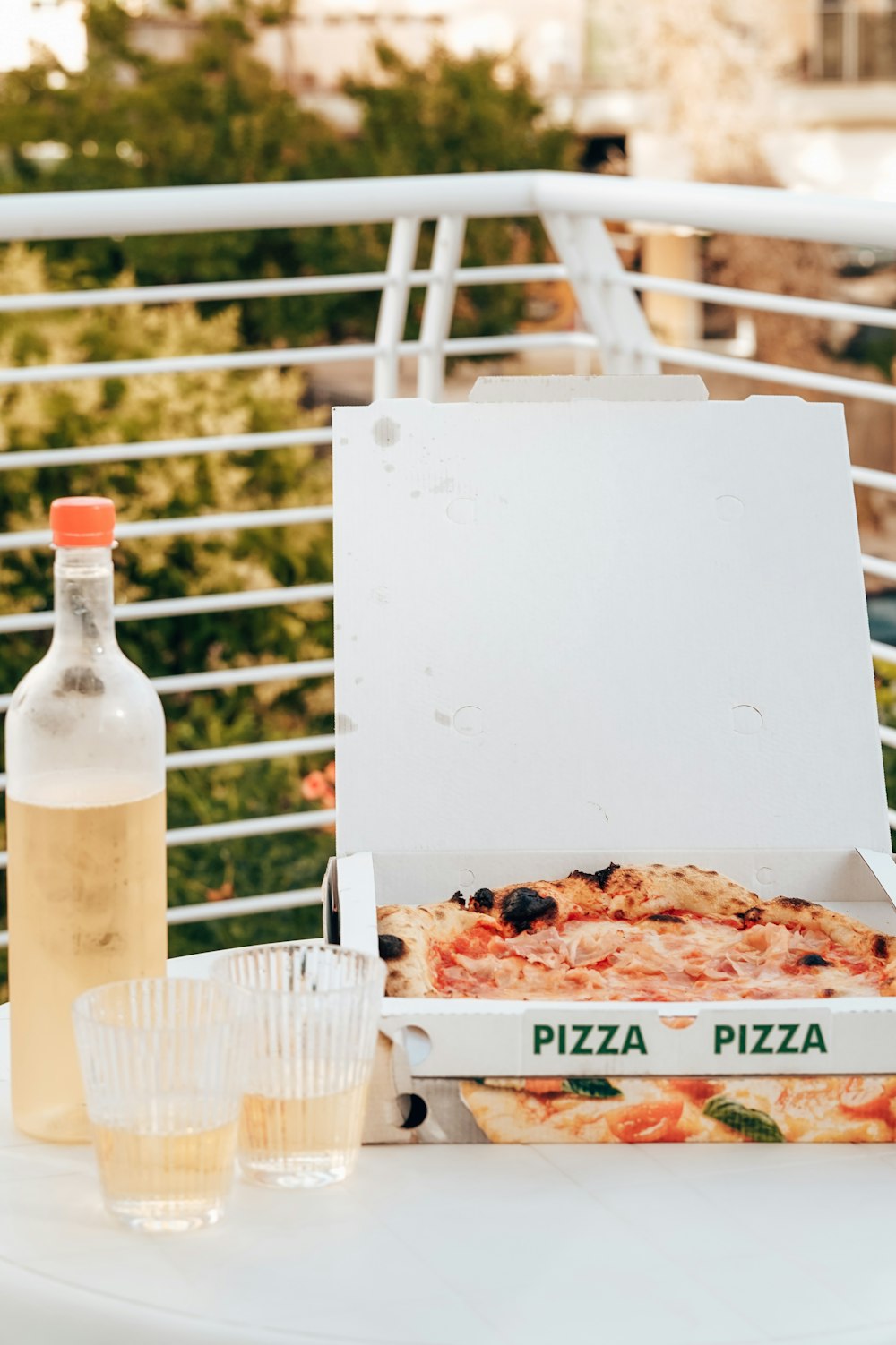 テーブルの上のピザの箱と水のボトル
