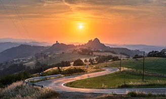 A scenic view of a winding country road at sunset, symbolizing the journey and stories shared on the blog.