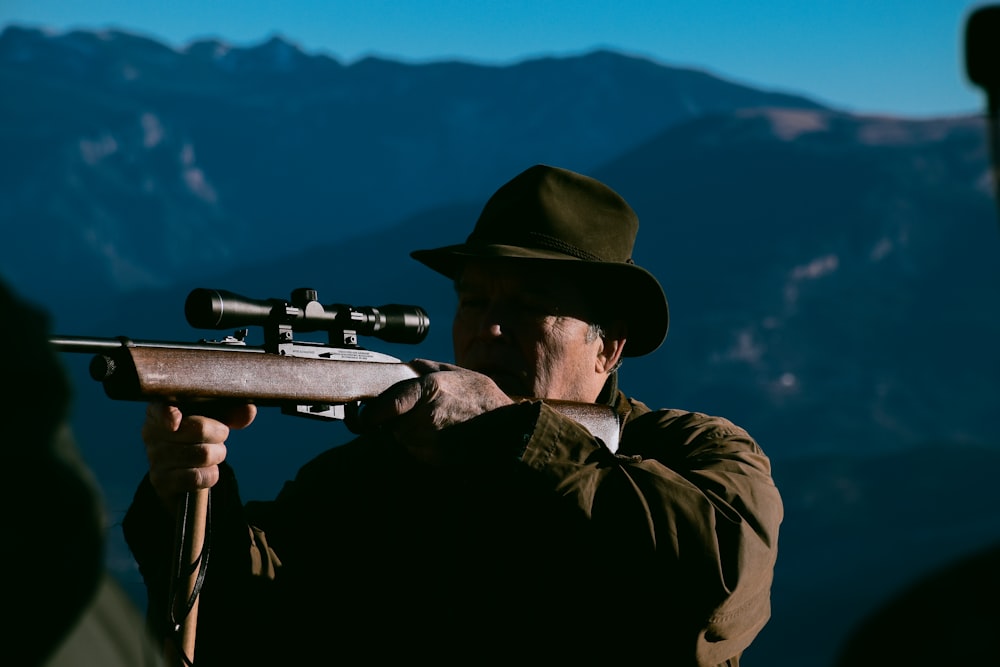 a man wearing a hat and holding a gun