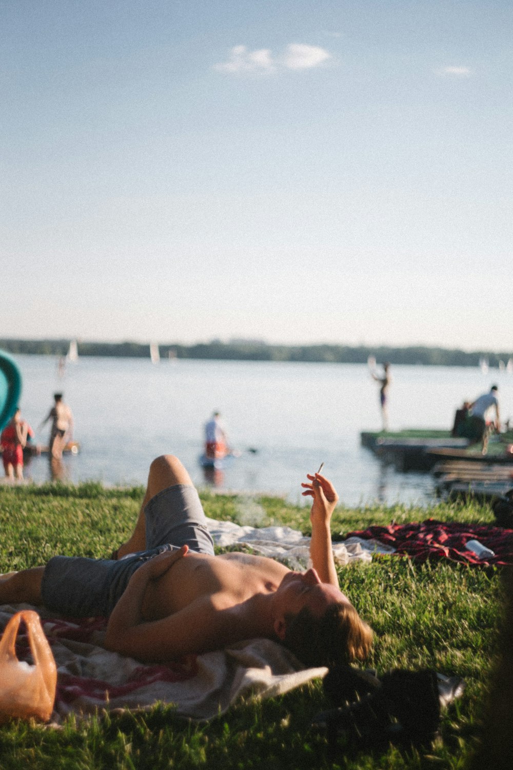 a person lying on grass near a body of water