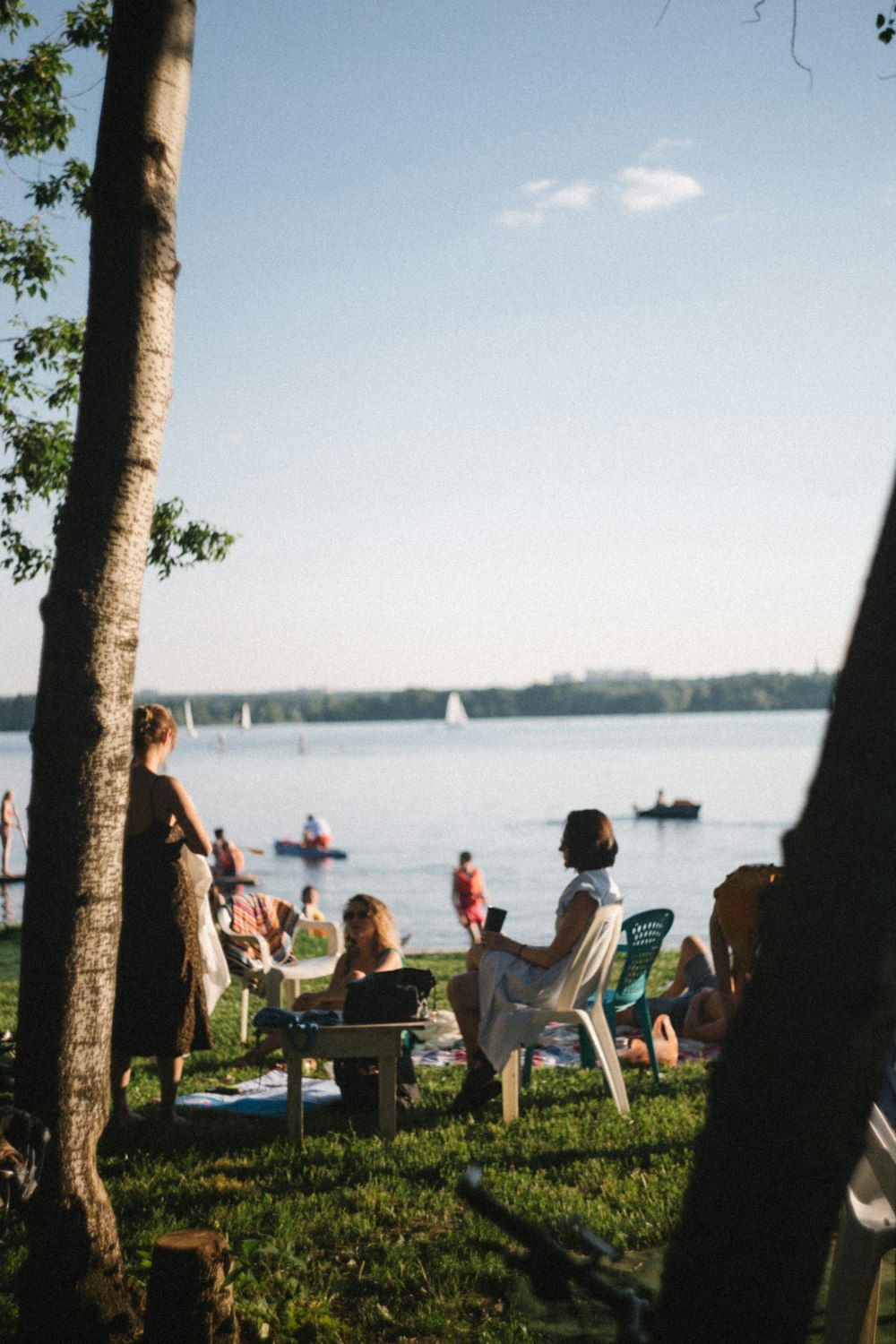 a group of people sitting on a bench next to a body of water